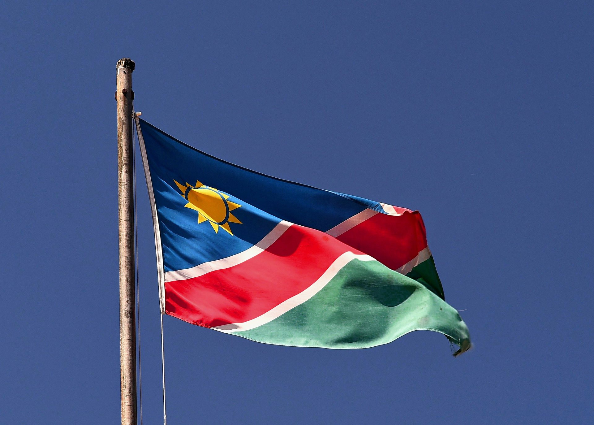 The Namibian flag flying against a clear blue sky